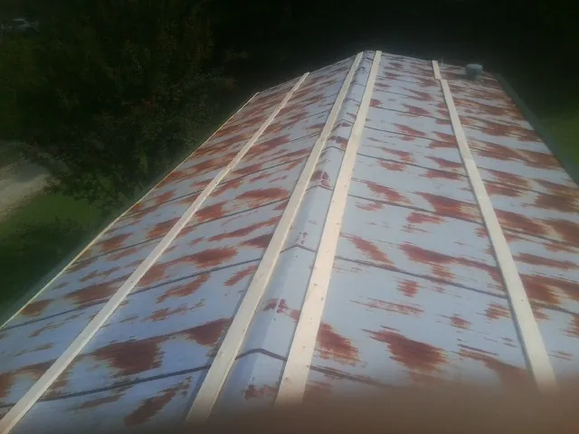 Rusted metal roof panels with new wood purlins before replacement — Storm Damage Roof Repair in Poca by Roofing Brothers