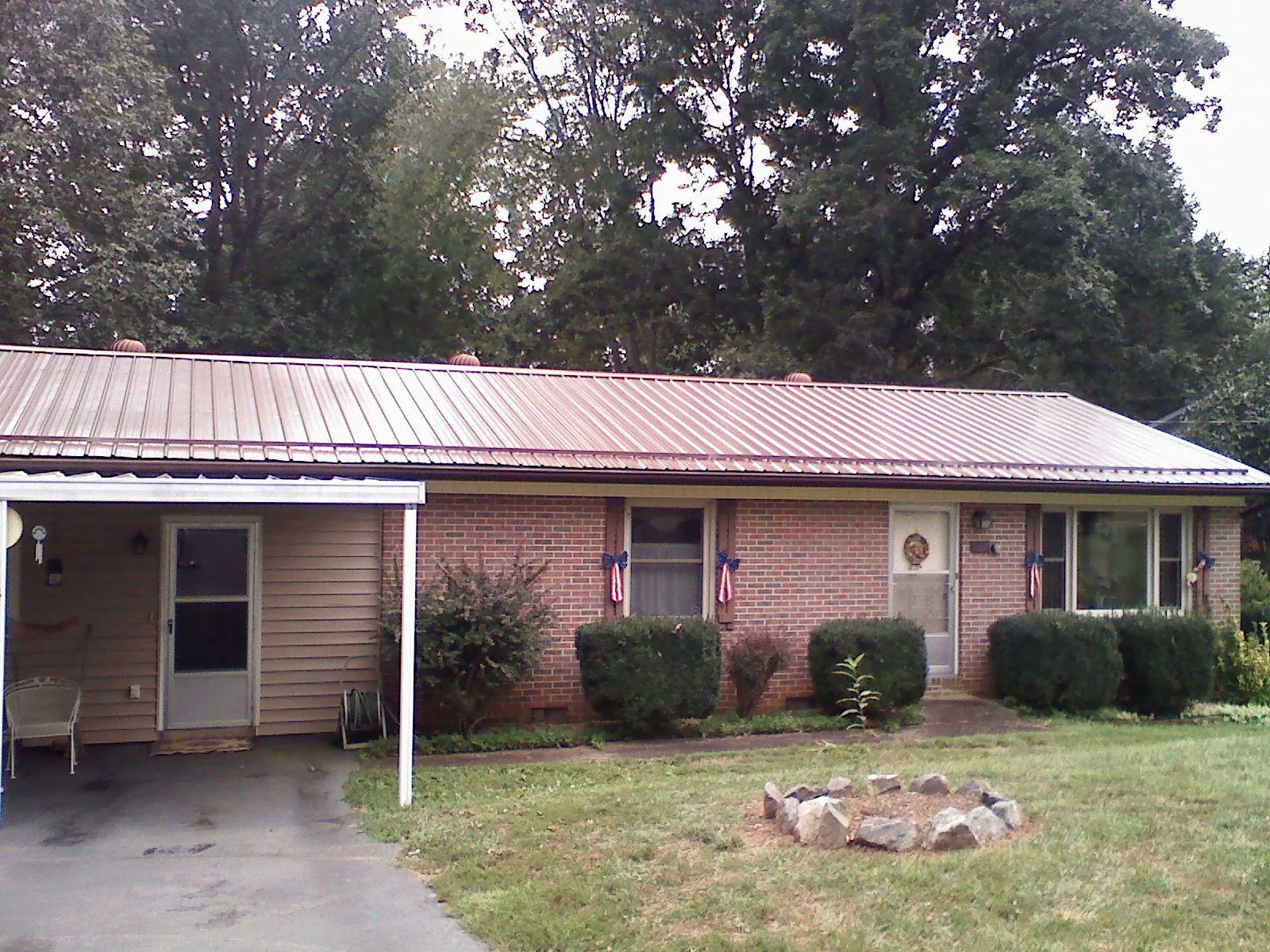 Bronze metal roof and carport on a brick ranch home — Roof Repair work by our crew in Poca
