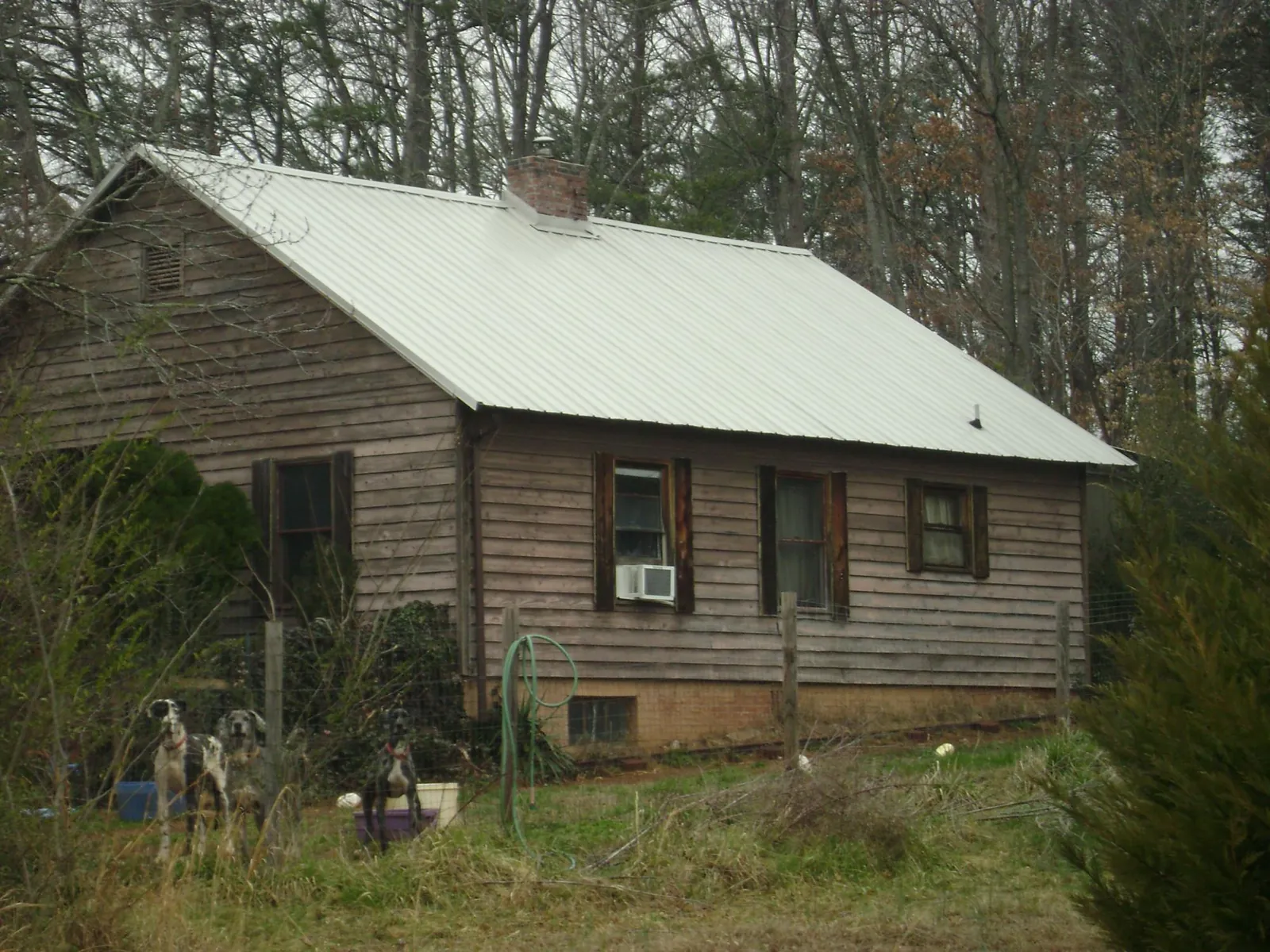White metal roof on an old wood sided farmhouse, from a Metal Roof Installation job in Poca